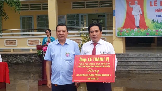 Ảnh Hiệu trưởng nhận Trao tặng quỹ khuyến học trường 500 quyển tập.